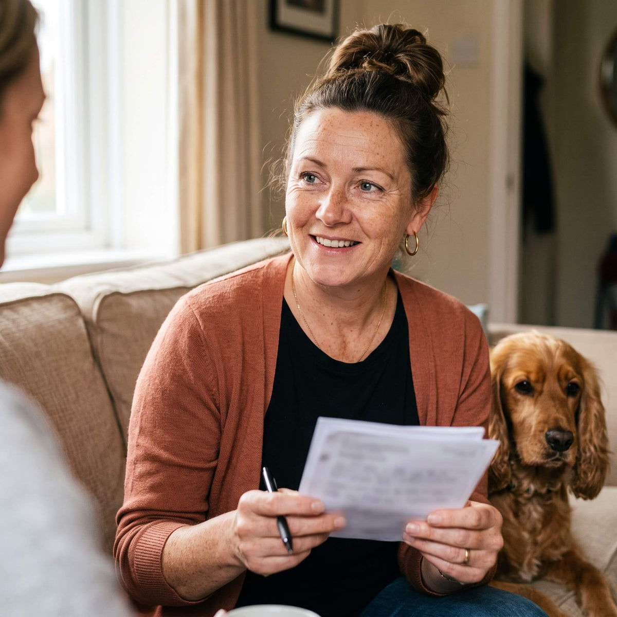 Pet sitter with a dog and a branded invoice on a laptop